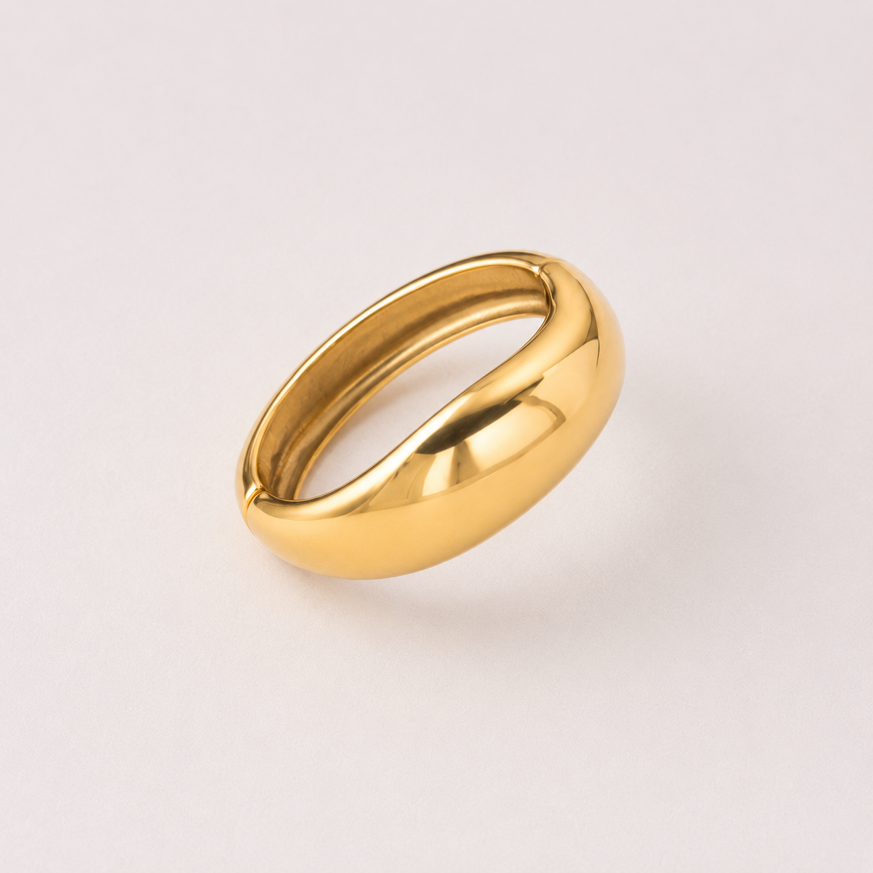 Gold bracelet on a light gray background