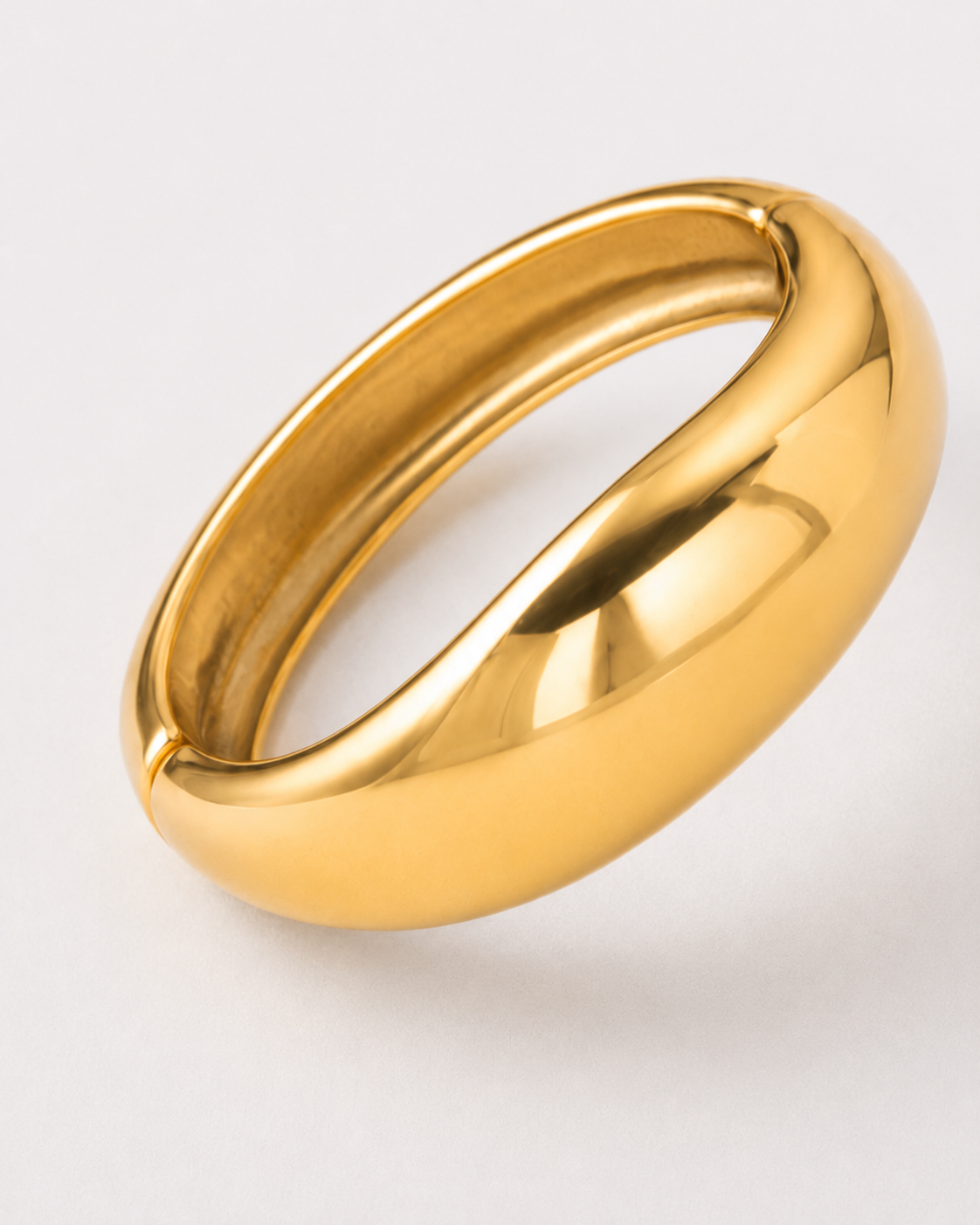 Gold bracelet on a light gray background